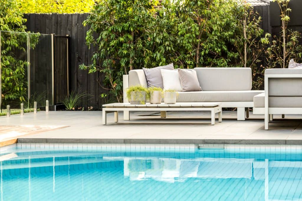 a pool with a couch and a table in the background